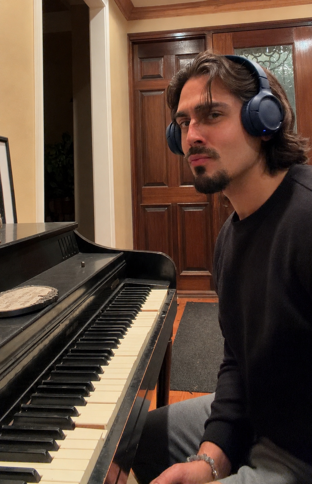 David Drae seated beside a piano